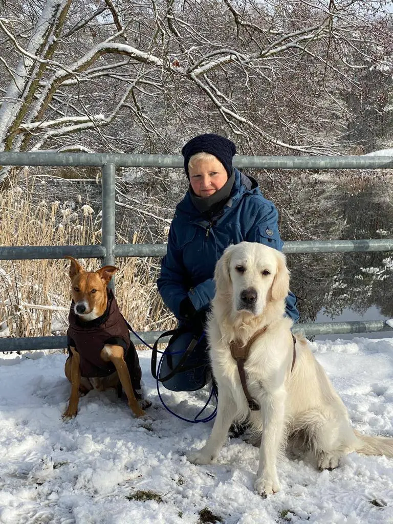Kerstin Herrmann mit ihren Hunden im verschneiten Wald - Mensch-Hund-Beziehung